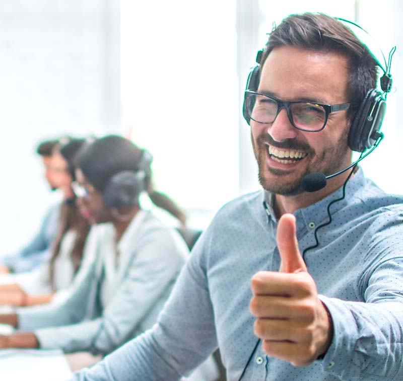 Customer Service Representative wearing a head set giving a thumbs up.